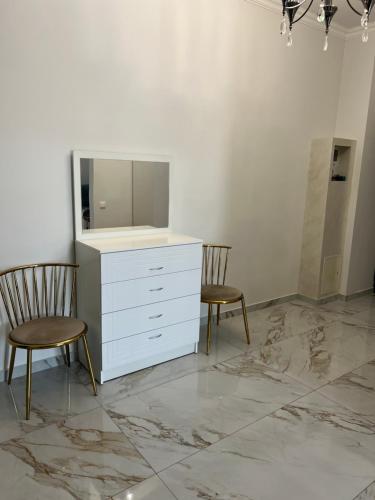 a white dresser and two chairs in a room at Apartment in centre of Yerevan in Yerevan