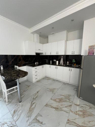 a kitchen with white cabinets and a table at Apartment in centre of Yerevan in Yerevan