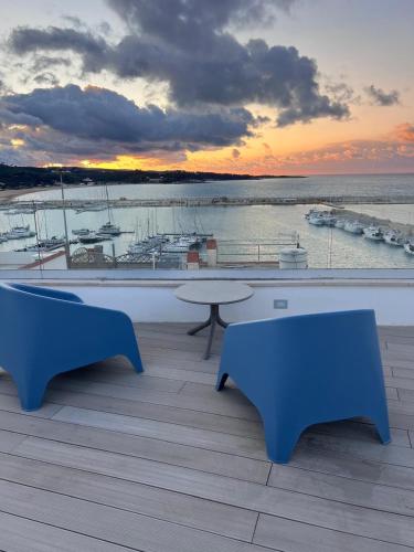 a balcony with two blue benches and a view of a harbor at North Wind Luxury Home in Vieste