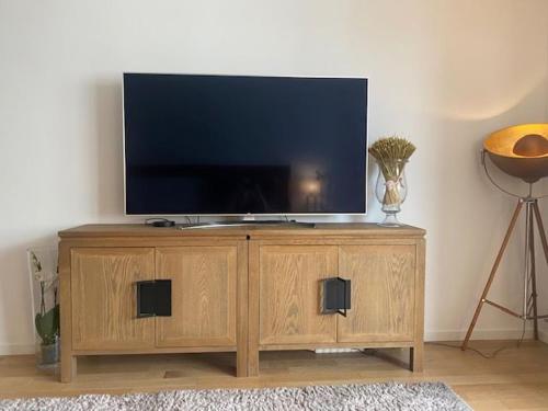 - une télévision sur un support en bois dans le salon dans l'établissement Logement entier aubenas, à Aubenas