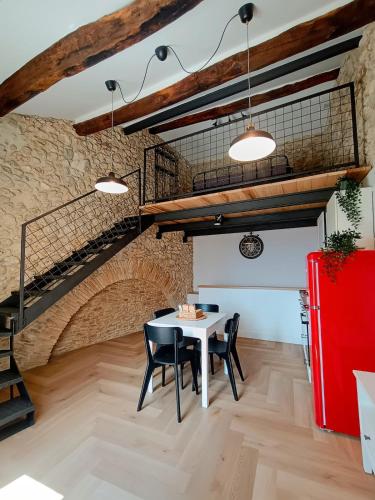 una sala da pranzo con tavolo, sedie e scala di La Piazzetta Panoramic Apartment a Veroli
