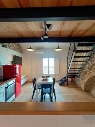 una cucina e una sala da pranzo con tavolo e scala di La Piazzetta Panoramic Apartment a Veroli