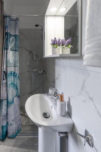 a white bathroom with a sink and a mirror at Levanda in Soullároi