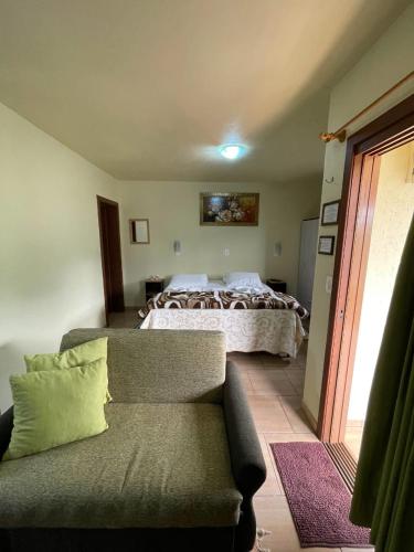 a bedroom with a bed and a couch and a bed at Pousada Verde Paraíso in Nova Petrópolis
