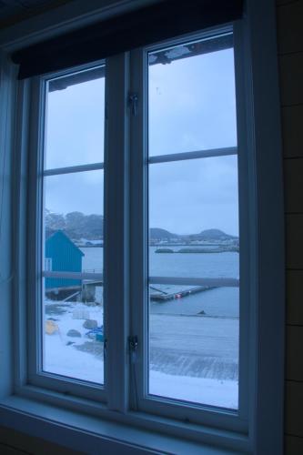 a window with a view of a body of water at Kræmmervika Rorbuer - Rustic Cabins & Hostel in Lofoten in Ballstad