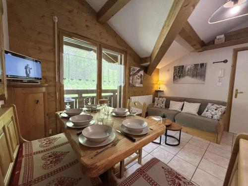 Il comprend une cuisine et un salon avec une table en bois. dans l'établissement Studio Cabine Mezzanine à Praz-Sur-Arly, proche pistes et lac, parking, balcon, 6 pers. - FR-1-603-105, à Praz-sur-Arly