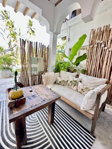 a living room with a couch and a table at Olamanga Beach Villa Adults Only in Jambiani