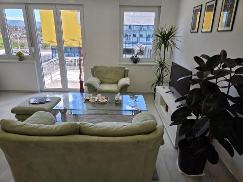 a living room with a couch and a glass table at Sarajevo Pulse Residence in Sarajevo