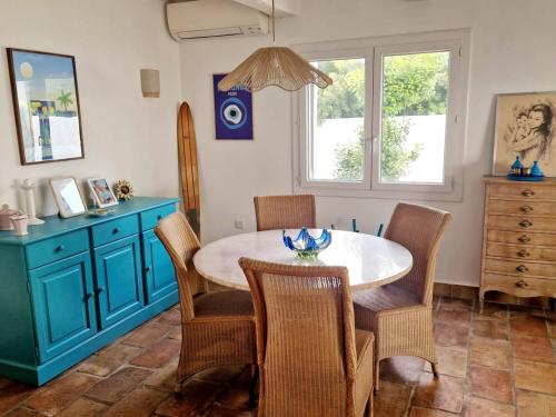 une salle à manger avec une table et des chaises bleues dans l'établissement Maison climatisée avec grand jardin, proche plage et commerces - FR-1-610-102, à Bormes-les-Mimosas