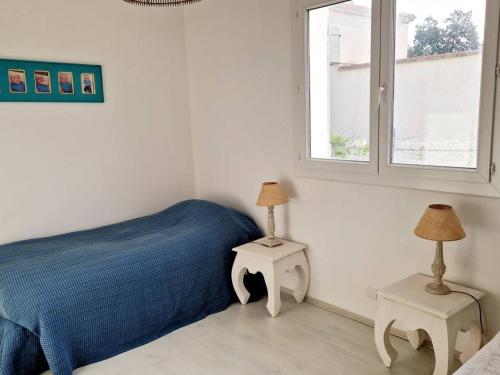 - une chambre avec un lit et deux lampes sur les tables dans l'établissement Maison climatisée avec grand jardin, proche plage et commerces - FR-1-610-102, à Bormes-les-Mimosas
