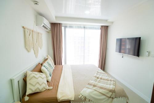 a bedroom with a bed and a window at Boho Apartment in Mai Khao Beach