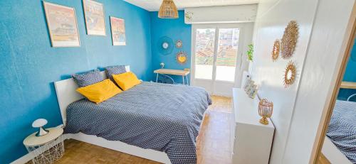 - une chambre avec des murs bleus et un lit avec des oreillers jaunes dans l'établissement CoeurDeSable - Appartement T3 Hyper Centre Arcachon - Parking, à Arcachon
