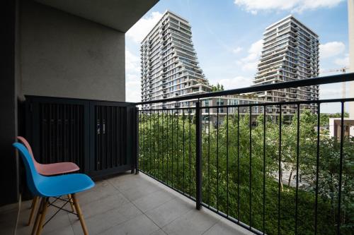 a balcony with a blue chair and two tall buildings at BW Vista in Belgrade