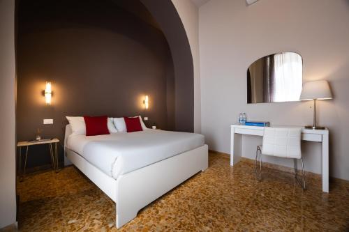 a bedroom with a white bed and a table and a mirror at Modern Apartments in Palestrina