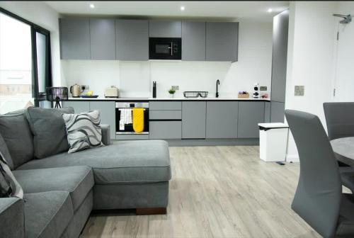 a living room with a couch and a kitchen at Modern 2 Bedroom Apt in Belfast in Belfast
