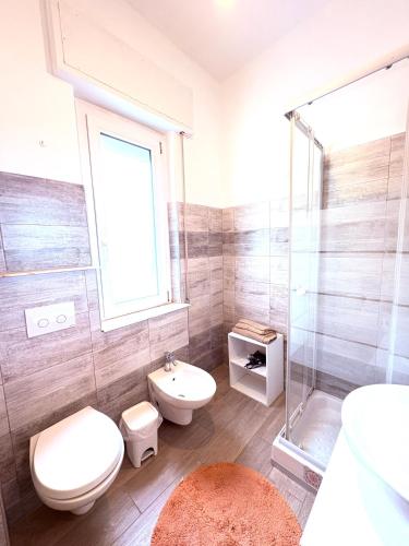 a bathroom with a toilet and a sink and a shower at Enjoy apartment Enjoy room in Porto Torres