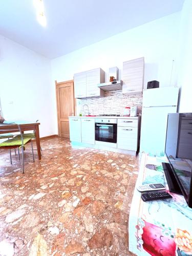 a kitchen with a floor that is covered in marble at Enjoy apartment Enjoy room in Porto Torres