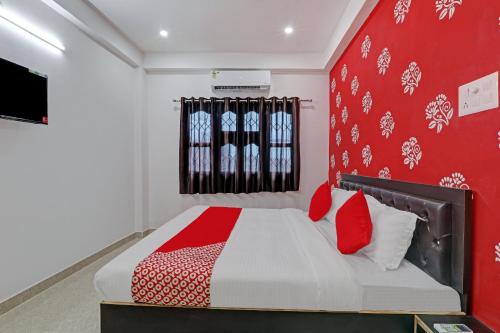 a bedroom with a bed with a red wall at Hotel O Sparrow Nest in Kakarmatha