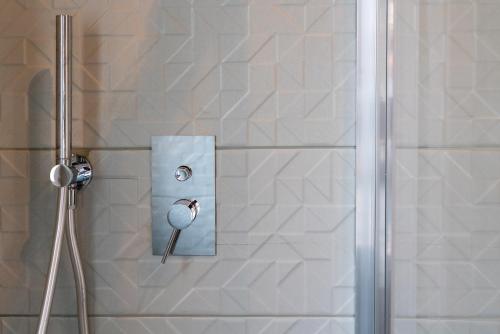 a shower with a glass door and a shower head at Hotel Baia di Talamone in Talamone
