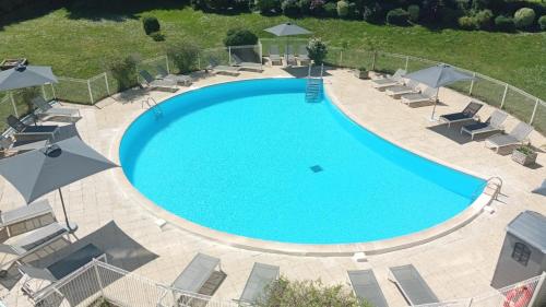 an overhead view of a swimming pool with chairs and umbrellas at Résidence New Rochelle in La Rochelle