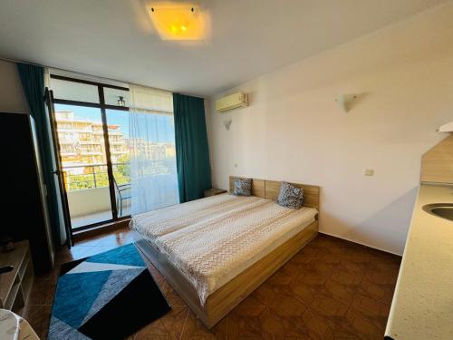 a bedroom with a bed and a large window at SAINT ELENA APART COMPLEX 47 Studio in Sunny Beach