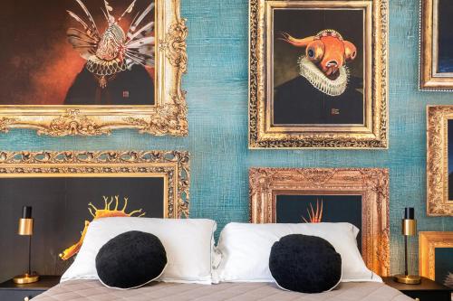 a bedroom with paintings on the wall and a bed at Hotel Baia di Talamone in Talamone