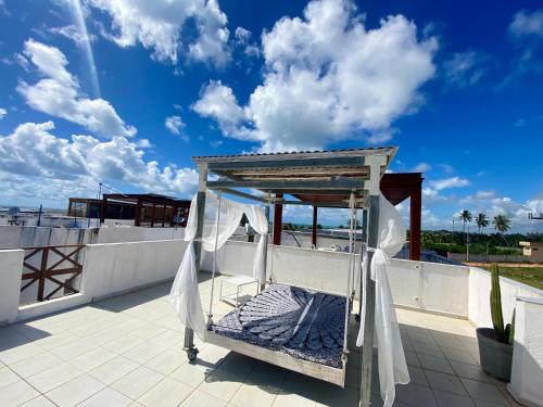 a bed on the roof of a house at Casa Paraiso Beira-Mar in Maracajaú