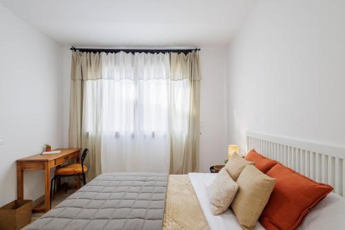 a bedroom with a bed with a desk and a window at Apartament a Sant Celoni, Montseny, Barcelona in San Celoni