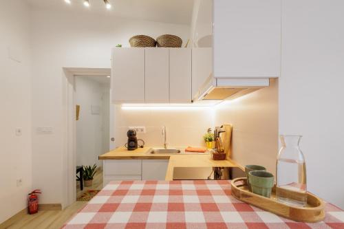 a kitchen with white cabinets and a checkered floor at Apartament a Sant Celoni, Montseny, Barcelona in San Celoni