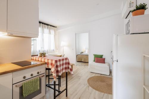 a kitchen with a table and a room with a bed at Apartament a Sant Celoni, Montseny, Barcelona in San Celoni