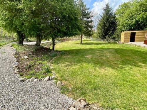 a garden with trees and a grass field at Deveron Valley Cottages in Marnoch