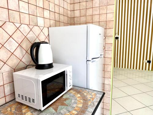 a microwave with a coffee pot on top of it next to a refrigerator at Colosseum Star Guest House in Rome