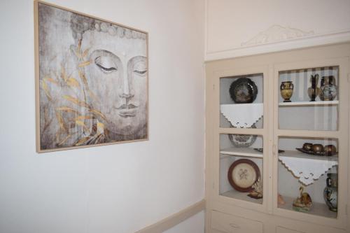 a painting on a wall next to a cabinet with vases at CapeVerde in Glóssa