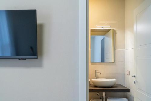 a bathroom with a sink and a tv on the wall at Hotel Baia di Talamone in Talamone