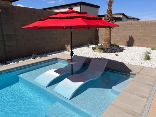 a red umbrella sitting next to a swimming pool at Comfy Casita Private Apartment with Shared Backyard in Hurricane