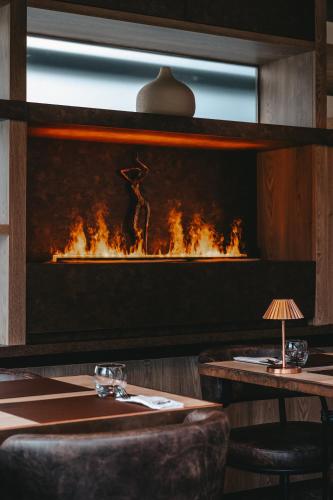 a fireplace in a restaurant with a table and chairs at Le Saint Georges in Gruyères
