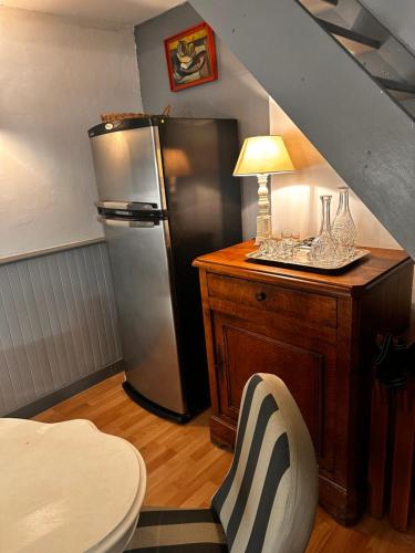 Il comprend une cuisine équipée d'un réfrigérateur et d'une table avec une chaise. dans l'établissement Le loft Rognes nouvel hébergement, à Rognes
