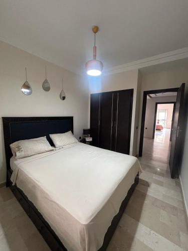 Un dormitorio con una gran cama blanca en una habitación. en Modern Apartment in Casablanca & beach Access, en Casablanca