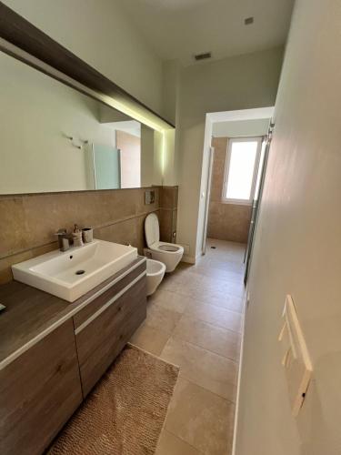 a bathroom with a sink and a toilet and a mirror at La Terrazza Sul Mare Luxury in Manfredonia