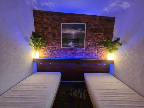 a room with two beds and a brick wall at Domek Przy Promenadzie Zdrojowej in Gołdap