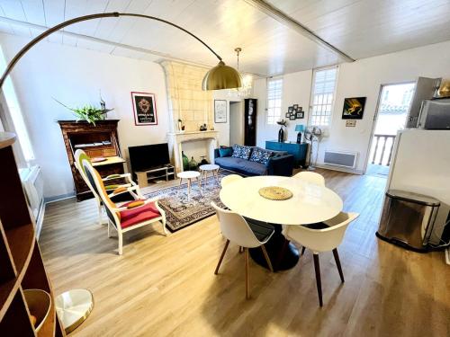 un salon avec une table et un canapé dans l'établissement Magnifique Appartement avec Terrasse - Centre Historique, à Bordeaux