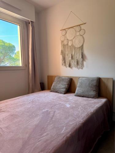 - une chambre avec un lit doté de draps violets et une fenêtre dans l'établissement Beautiful apartment with pool, golf & beaches, à Saint-Raphaël