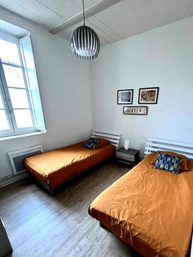 une chambre avec deux lits et une grande fenêtre dans l'établissement Magnifique Appartement avec Terrasse - Centre Historique, à Bordeaux