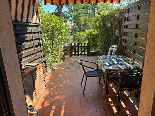 a patio with a table and chairs on a brick patio at Rez-de-jardin proche plage in Cavalaire-sur-Mer