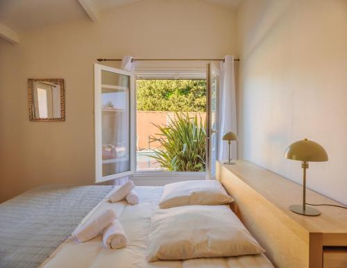 une chambre avec un lit avec des oreillers et une fenêtre dans l'établissement Charmante maison - piscine privée, Calme & Nature, à Mollégès