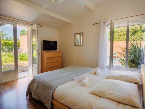 une chambre avec un grand lit et une télévision dans l'établissement Charmante maison - piscine privée, Calme & Nature, à Mollégès
