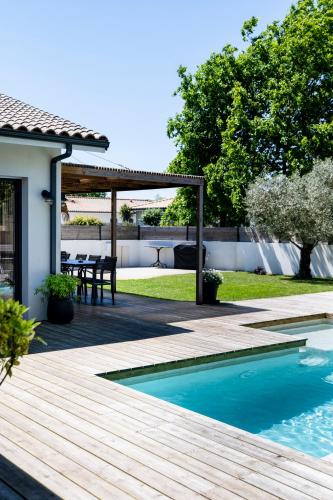 une arrière-cour avec une terrasse en bois et une table de pique-nique dans l'établissement Superbe villa avec piscine, au Teich