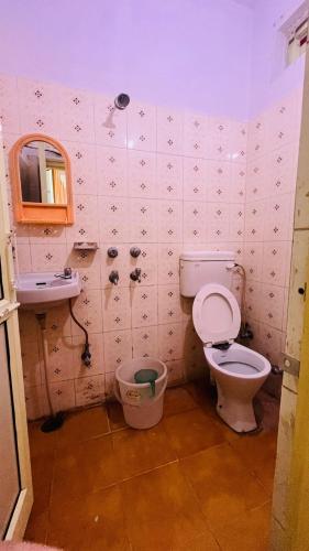 a bathroom with a toilet and a sink at Hotel Laxman Ganga in Rishīkesh