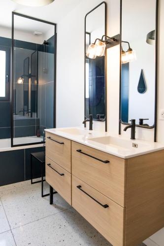 une salle de bain avec un lavabo et deux miroirs dans l'établissement Superbe villa avec piscine, au Teich