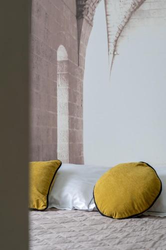a bed with two yellow pillows on it at Hotel Baia di Talamone in Talamone